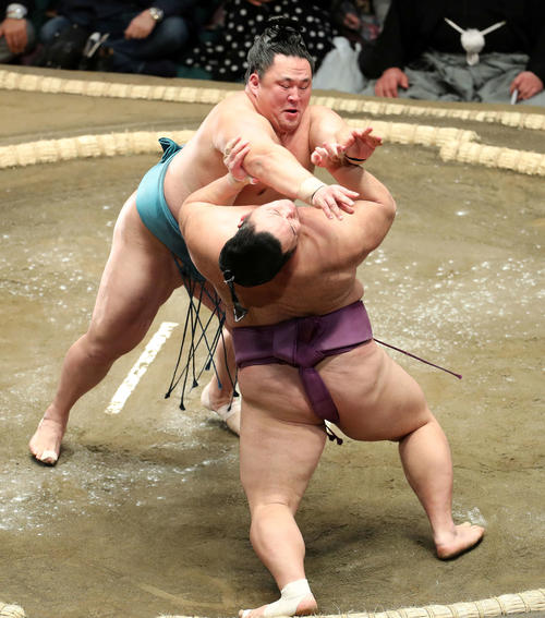 玉鷲(後方)の攻めを耐える朝乃山(撮影・鈴木正人)