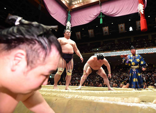 白鵬（右）は突き落としで妙義龍に敗れ2敗目を喫した。手前はこの日2敗とし引き揚げる鶴竜（撮影・小沢裕）
