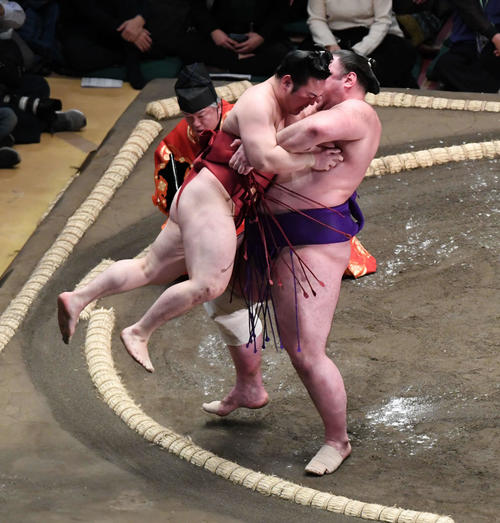 吊り出される炎鵬（左）は最後まで暴れて栃ノ心を苦しめる（撮影・山崎安昭）