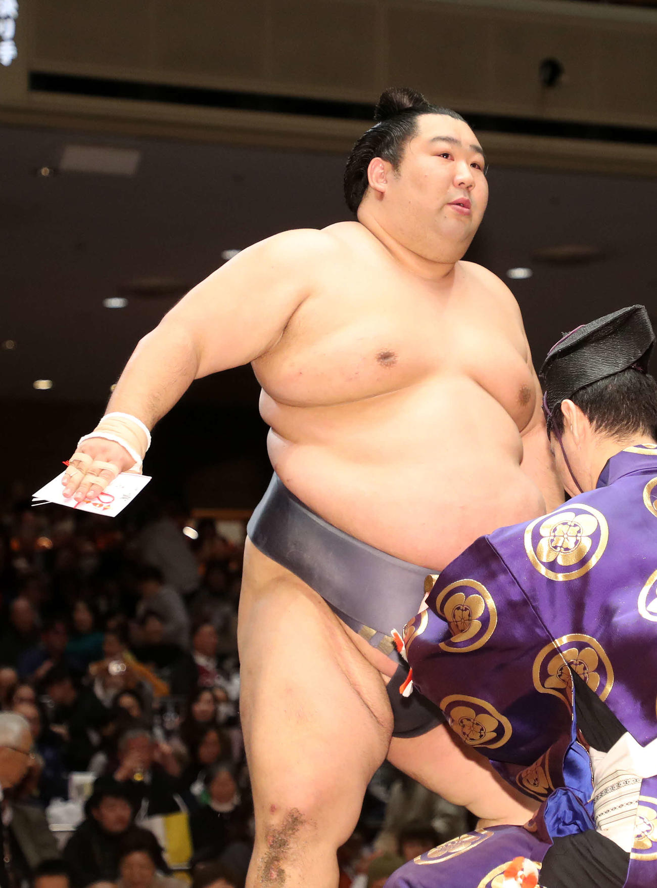 懸賞金の束を手に土俵を引き揚げる徳勝龍（撮影・鈴木正人）