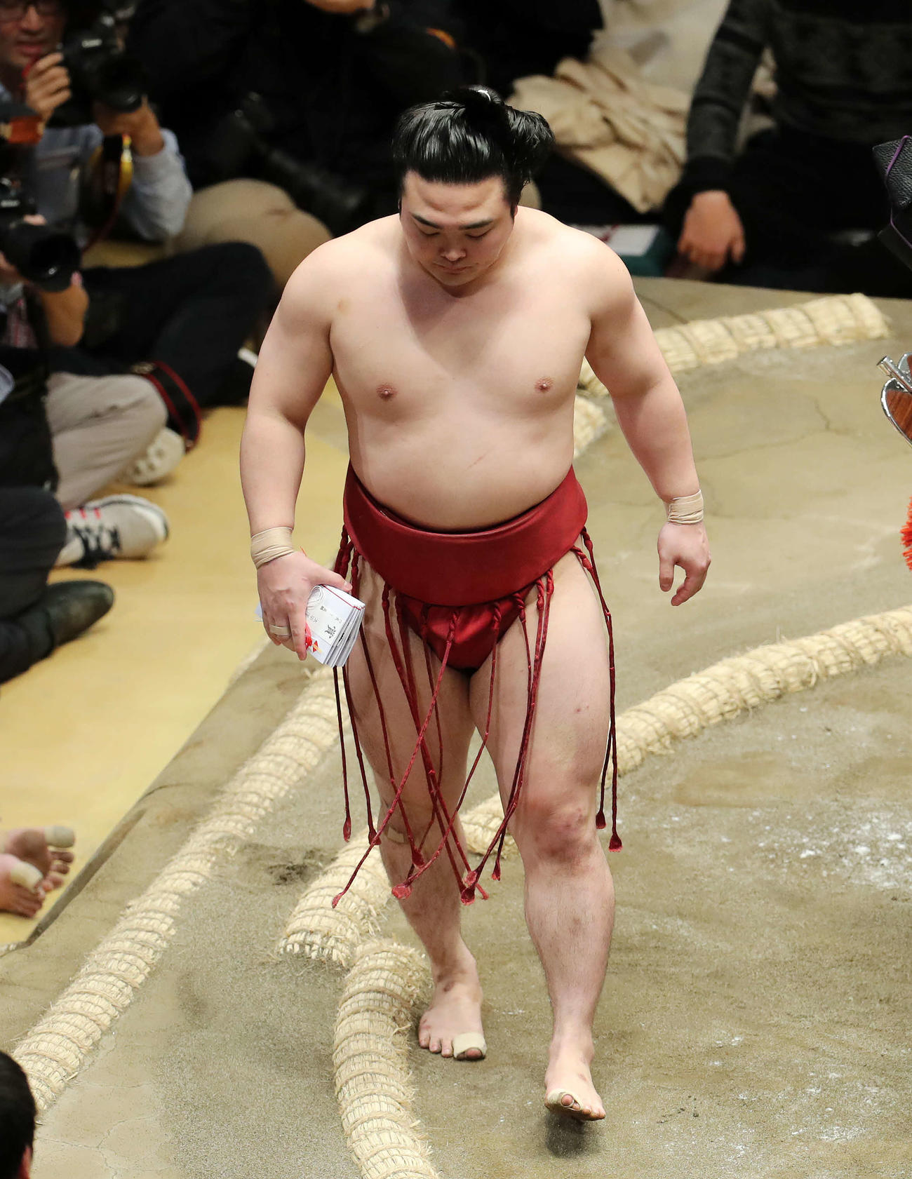 懸賞金の束を手に土俵を引き揚げる炎鵬（撮影・鈴木正人）