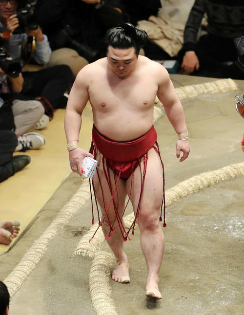 懸賞金の束を手に土俵を引き揚げる炎鵬（撮影・鈴木正人）
