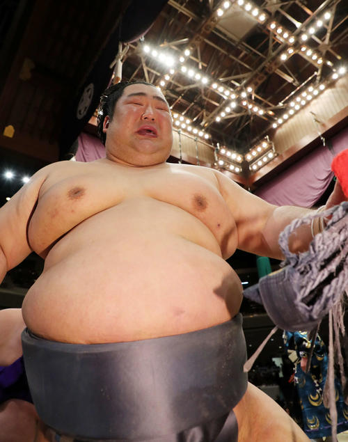 懸賞金の束を手に涙ぐみながら土俵を引き揚げる徳勝龍(撮影・鈴木正人)