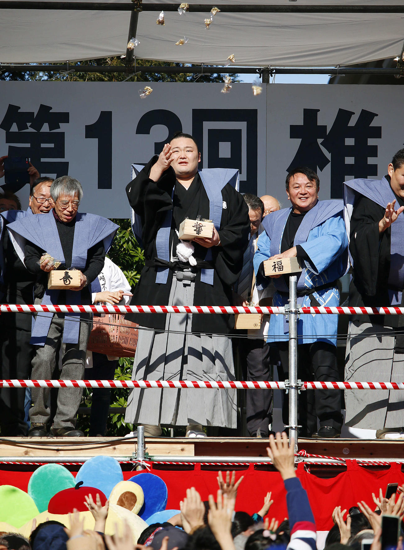 都内で豆まきをする朝乃山（中央）