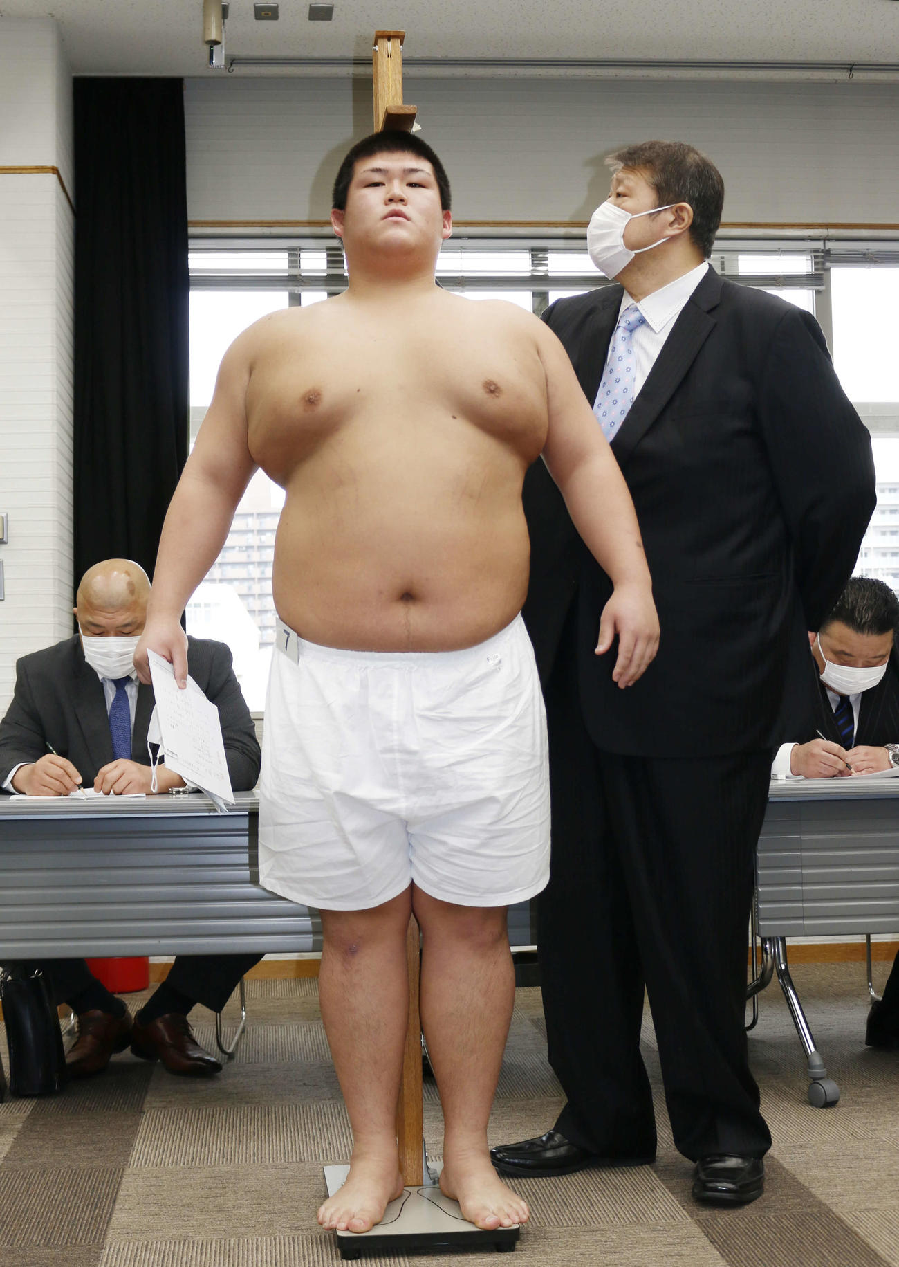 新弟子検査で身長を計測する中大4年の納谷幸林（中央）と錦戸親方（右）（撮影・佐藤礼征）