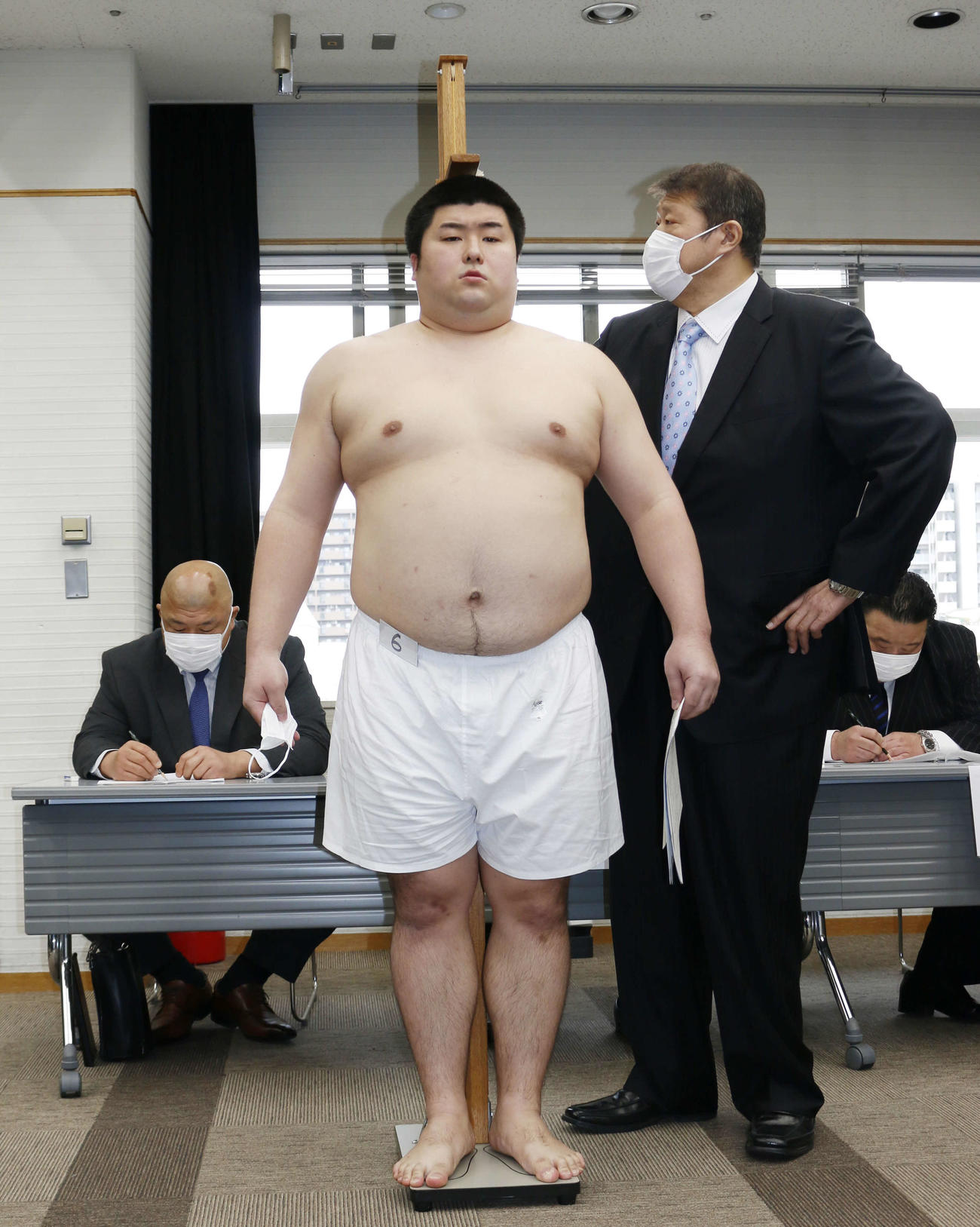 新弟子検査で身長を計測する東洋大4年の深井拓斗（中央）と錦戸親方（右）（撮影・佐藤礼征）