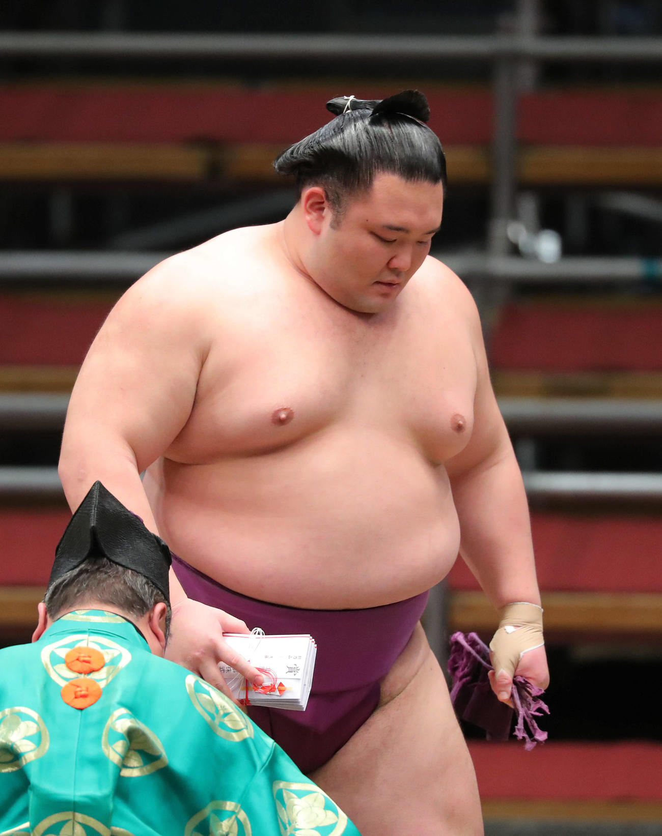 遠藤を小手投げで破り、懸賞金の束を手に土俵から引き揚げる朝乃山（撮影・河田真司）