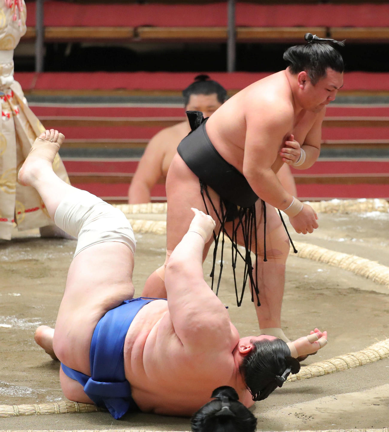 碧山（左）を下手投げで破る照強は右腕を押さえる（撮影・河田真司）