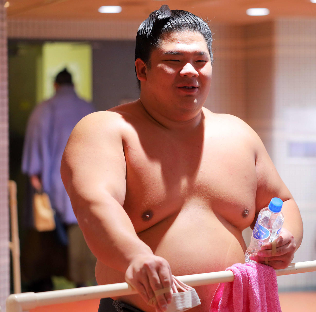 記者の質問に笑顔で答える宇良。後方左は支度部屋に入る碧山（撮影・河田真司）