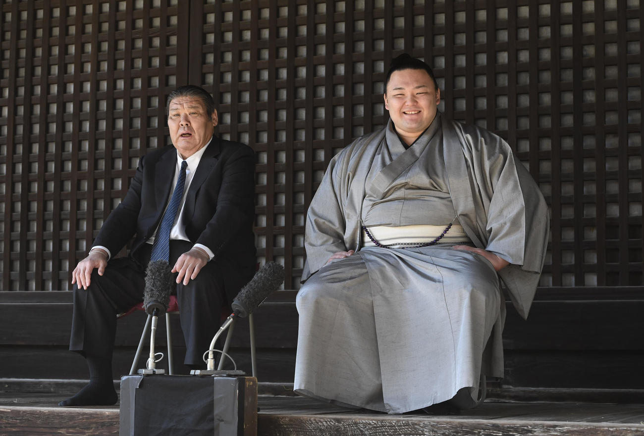 一夜明け会見で記者の質問に笑顔で答える朝乃山（右）。左は高砂親方（代表撮影）