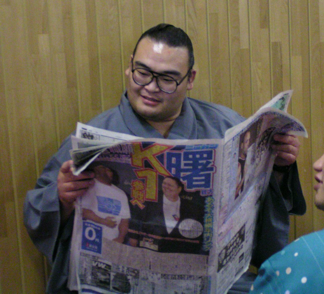 福岡市の福岡国際センターで行われた前夜祭の支度部屋で、曙親方のKー1参戦を伝える本紙に目を通す小結高見盛（2003年11月6日撮影）