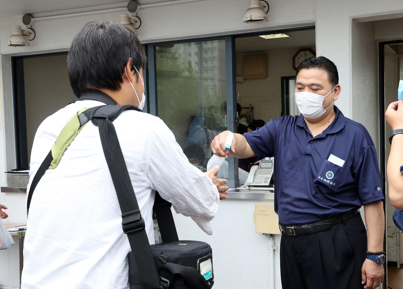 入場時、手指を消毒される報道陣（撮影・鈴木正人）