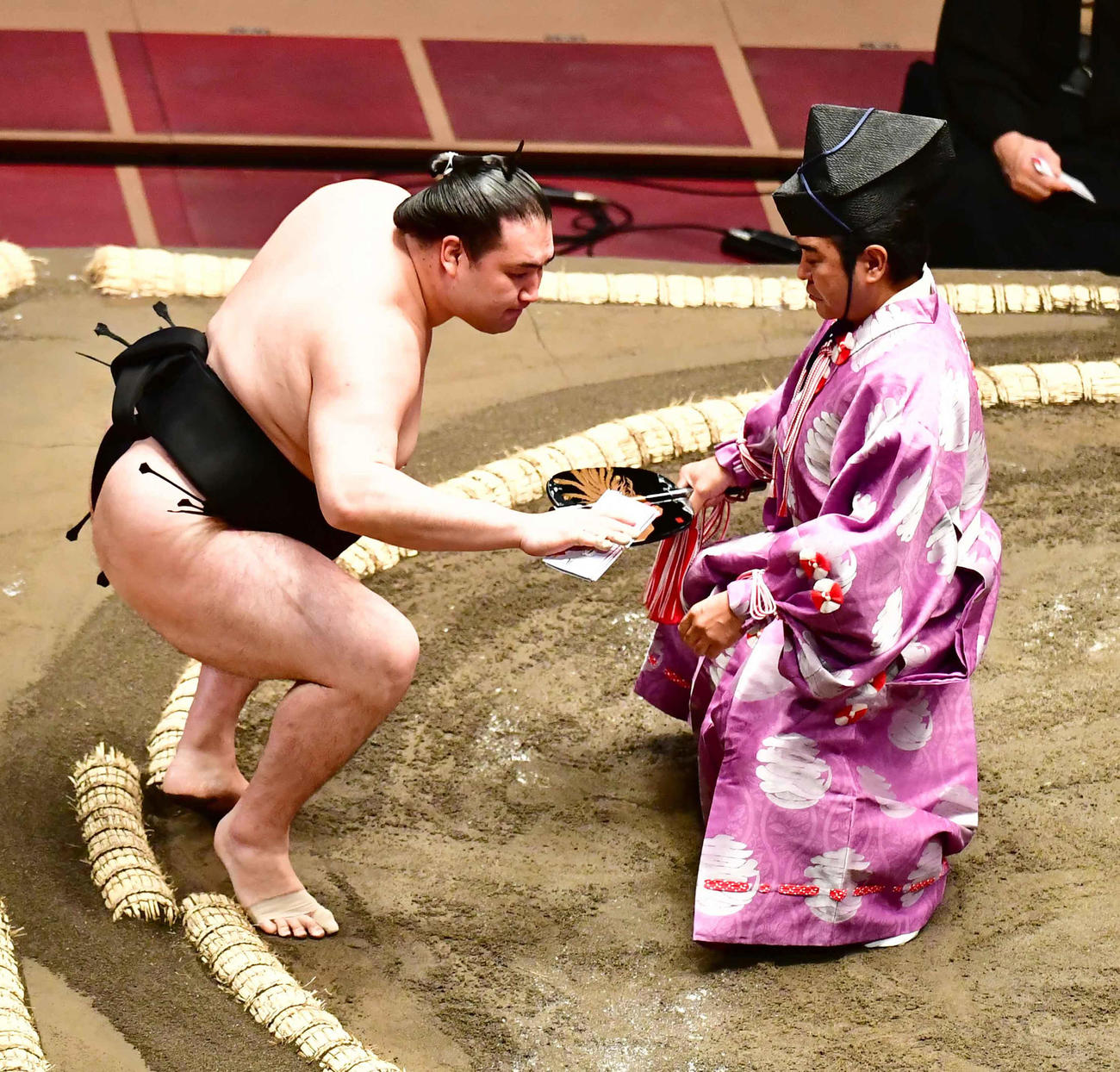 初日を出し懸賞を手にする竜電（撮影・小沢裕）