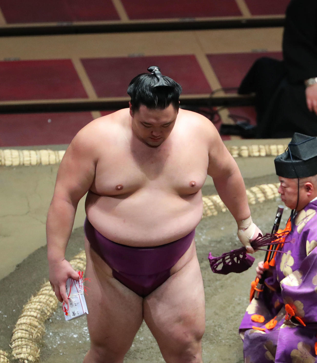 豊山を下し、懸賞金の束を手に土俵から引き揚げる朝乃山（撮影・河田真司）