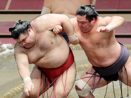 妙義龍（右）の攻めに耐える高安（撮影・河田真司）