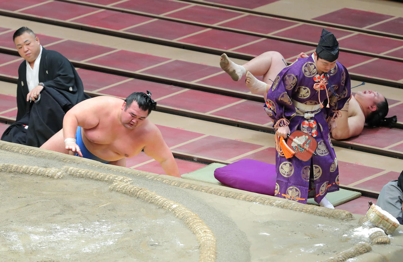 玉鷲（右）を寄り切りで破り、勢いで土俵下に落ちる琴奨菊（撮影・河田真司）　　