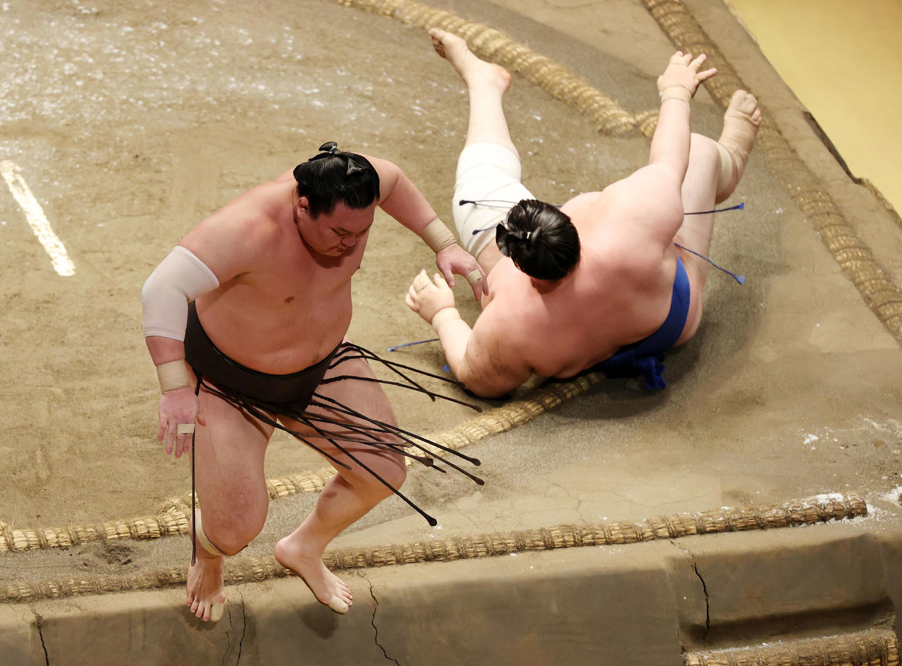 碧山（右）をはたき込みで破り土俵を飛び出る白鵬（撮影・鈴木正人）