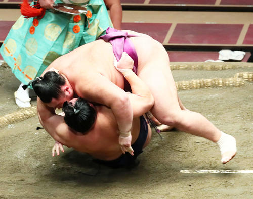 朝乃山（上）はすくい投げで北勝富士を破る（撮影・足立雅史）