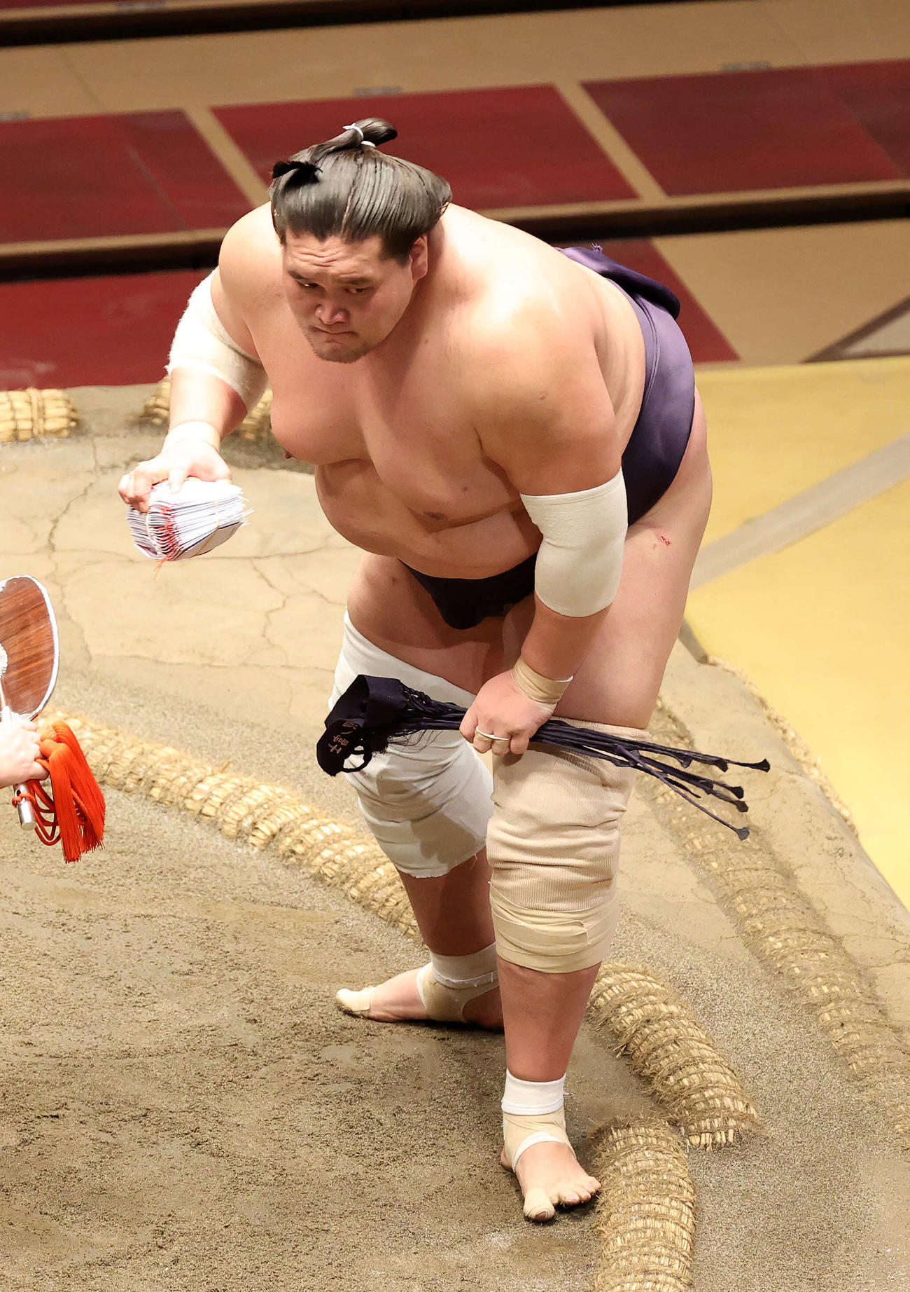 懸賞金の束を手に土俵を引き揚げる照ノ富士（撮影・鈴木正人）