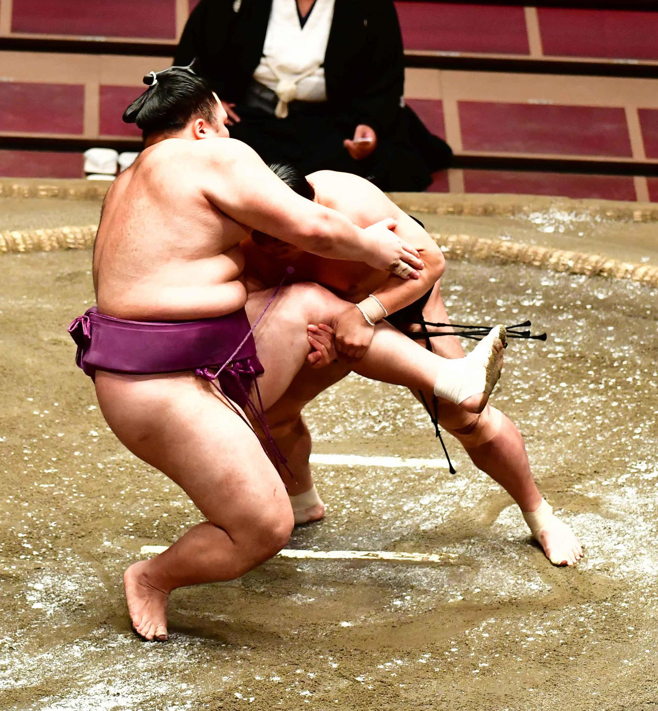 朝乃山（左）の左足をつかむ照強（撮影・小沢裕）