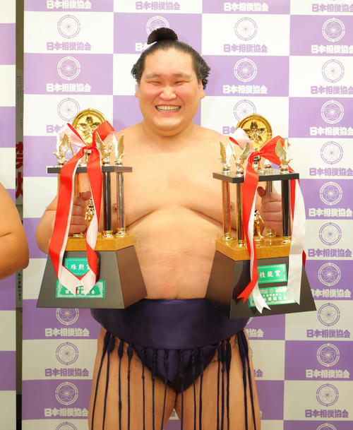 三賞の記念撮影で殊勲賞と技能賞のトロフィーを手に笑顔を見せる照ノ富士(代表撮影)
