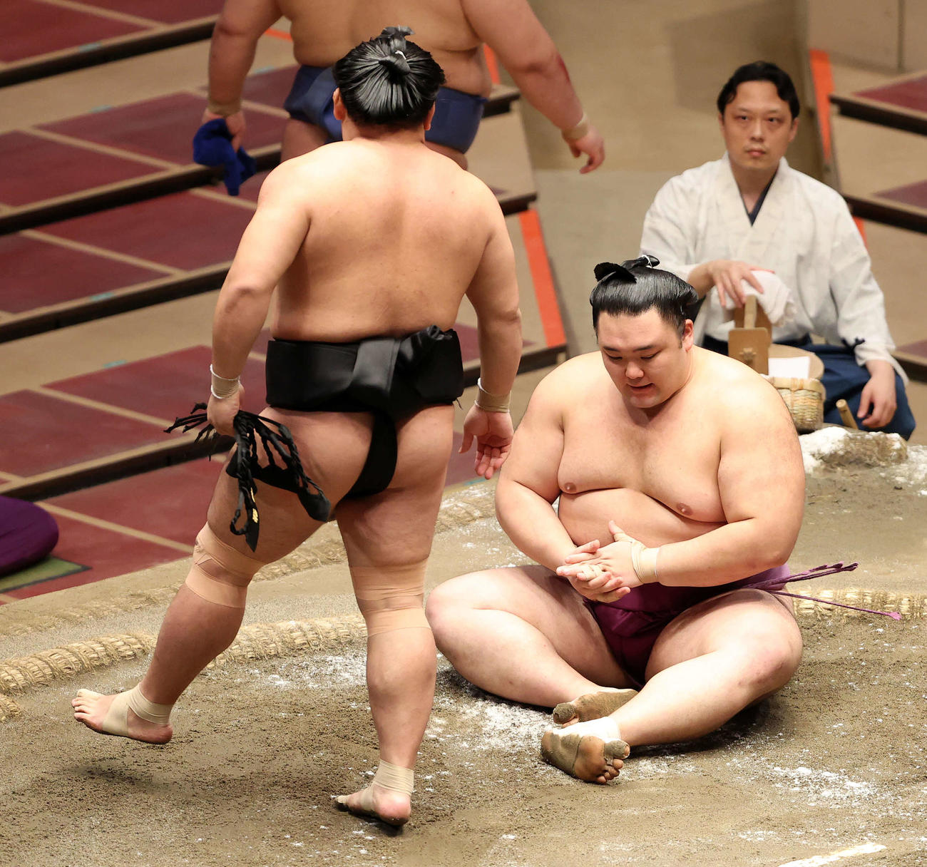 照強（左）に足取りで敗れて座り込む朝乃山（撮影・鈴木正人）