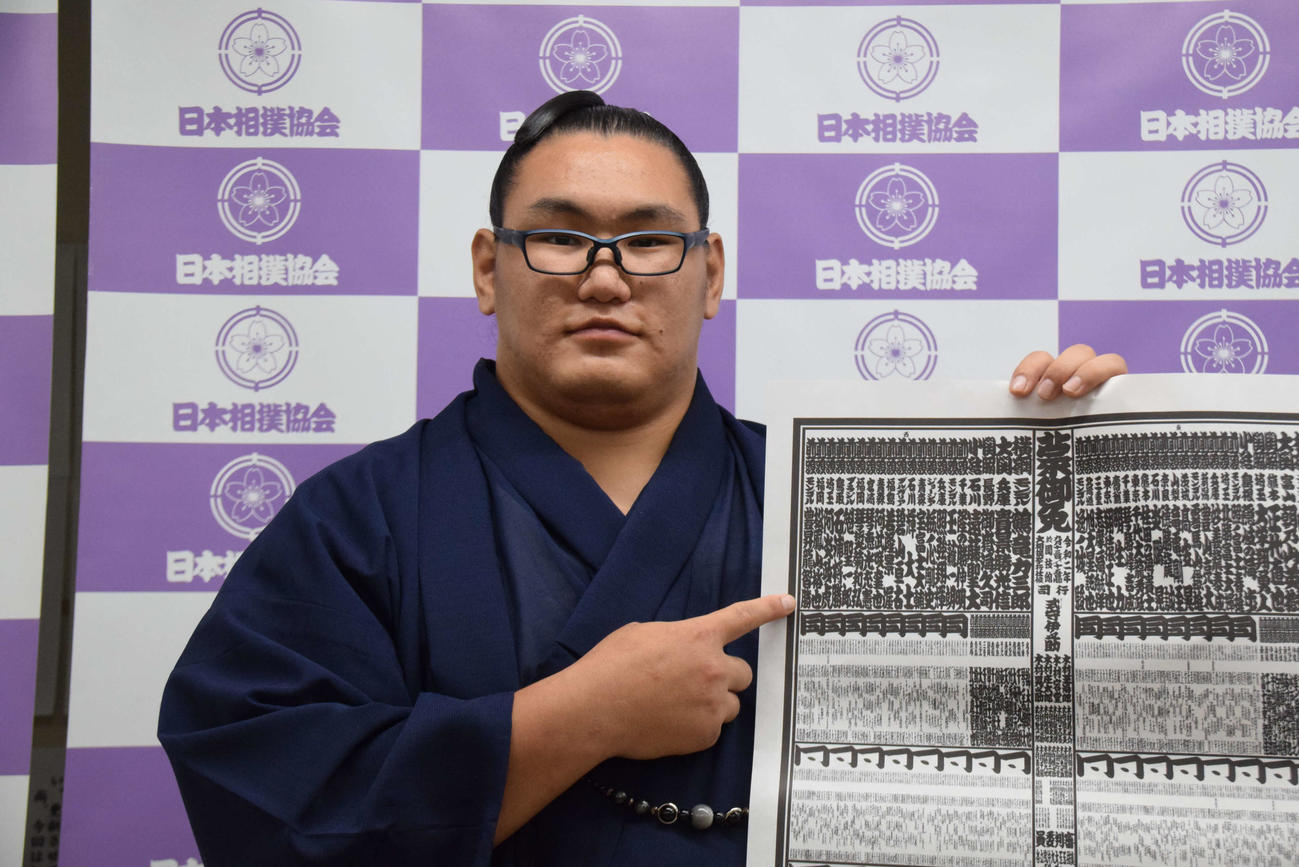 秋場所の番付表に記載されている幕内力士となった自身のしこ名を指さす豊昇龍