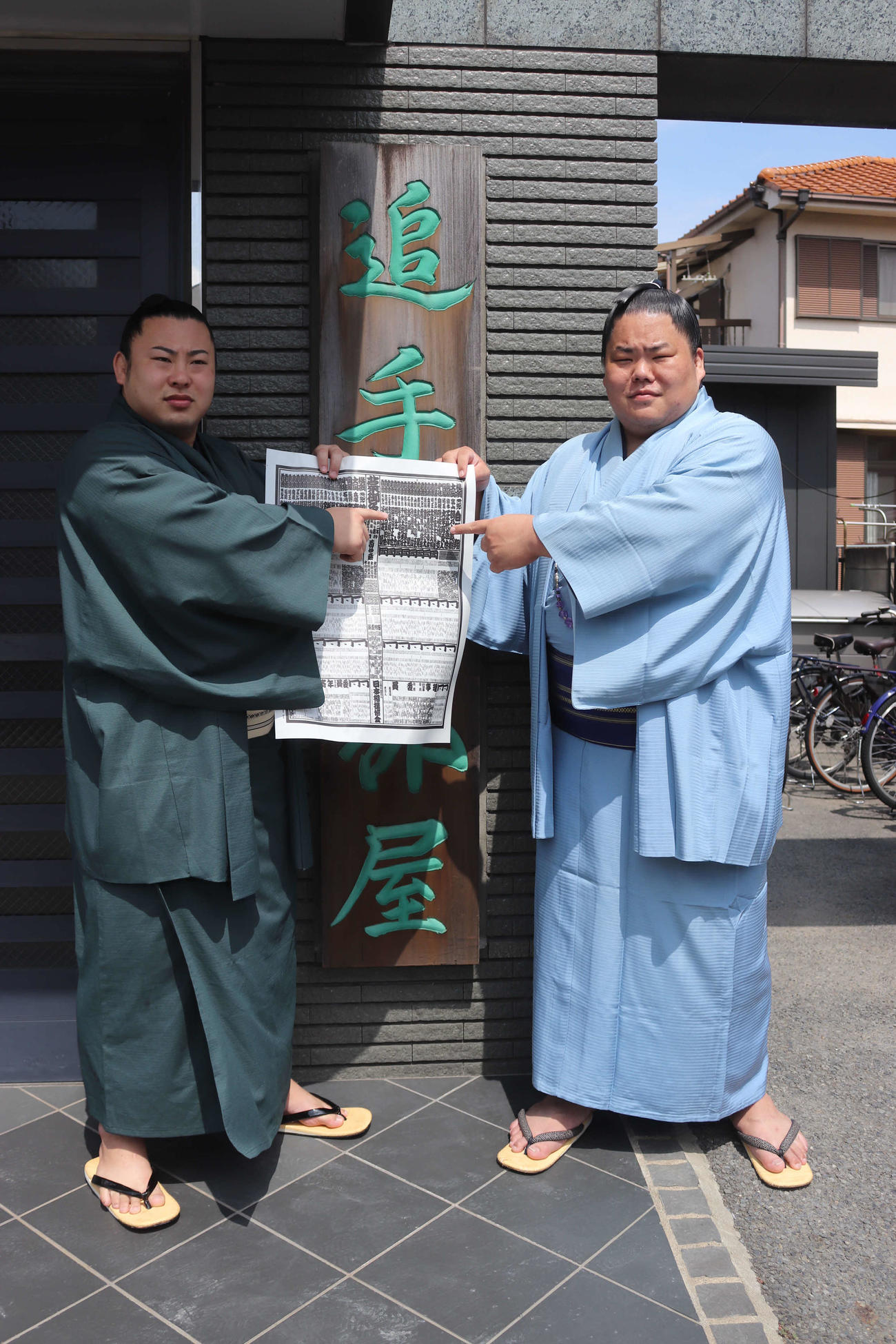 埼玉県草加市の追手風部屋で秋場所の番付表に記載されている自身のしこ名を指さす新関脇の大栄翔（右）と新入幕の翔猿