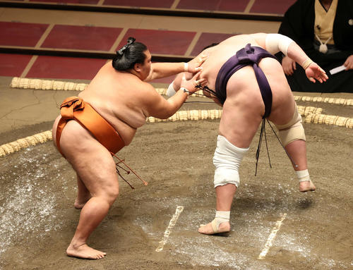 照ノ富士（右）を送り出しで破る御嶽海（撮影・鈴木正人）
