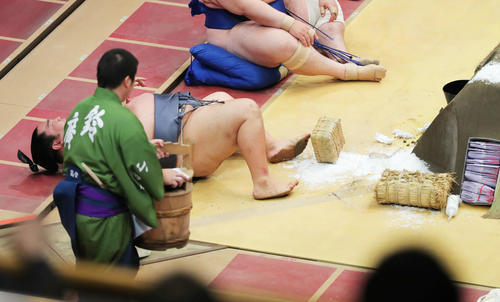 琴恵光に押し出され、まき塩と一緒に土俵下に落ちる徳勝龍(撮影・河田真司)