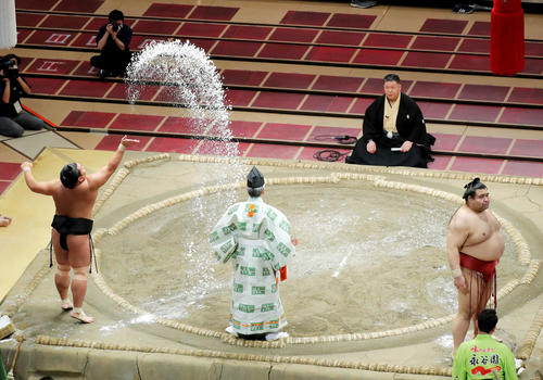 豪快に塩をまく照強(左)と、観客席を見つめる高安(撮影・河田真司)