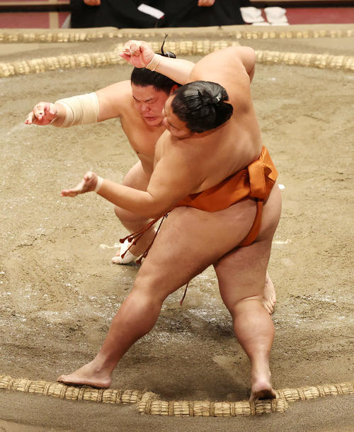 御嶽海(手前)を押し出しで破る大栄翔(撮影・鈴木正人)