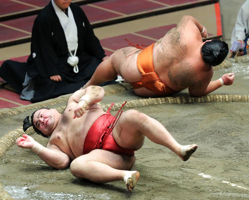 御嶽海（右）を肩すかしで破り、勢いで転がる高安（撮影・河田真司）　　　　　