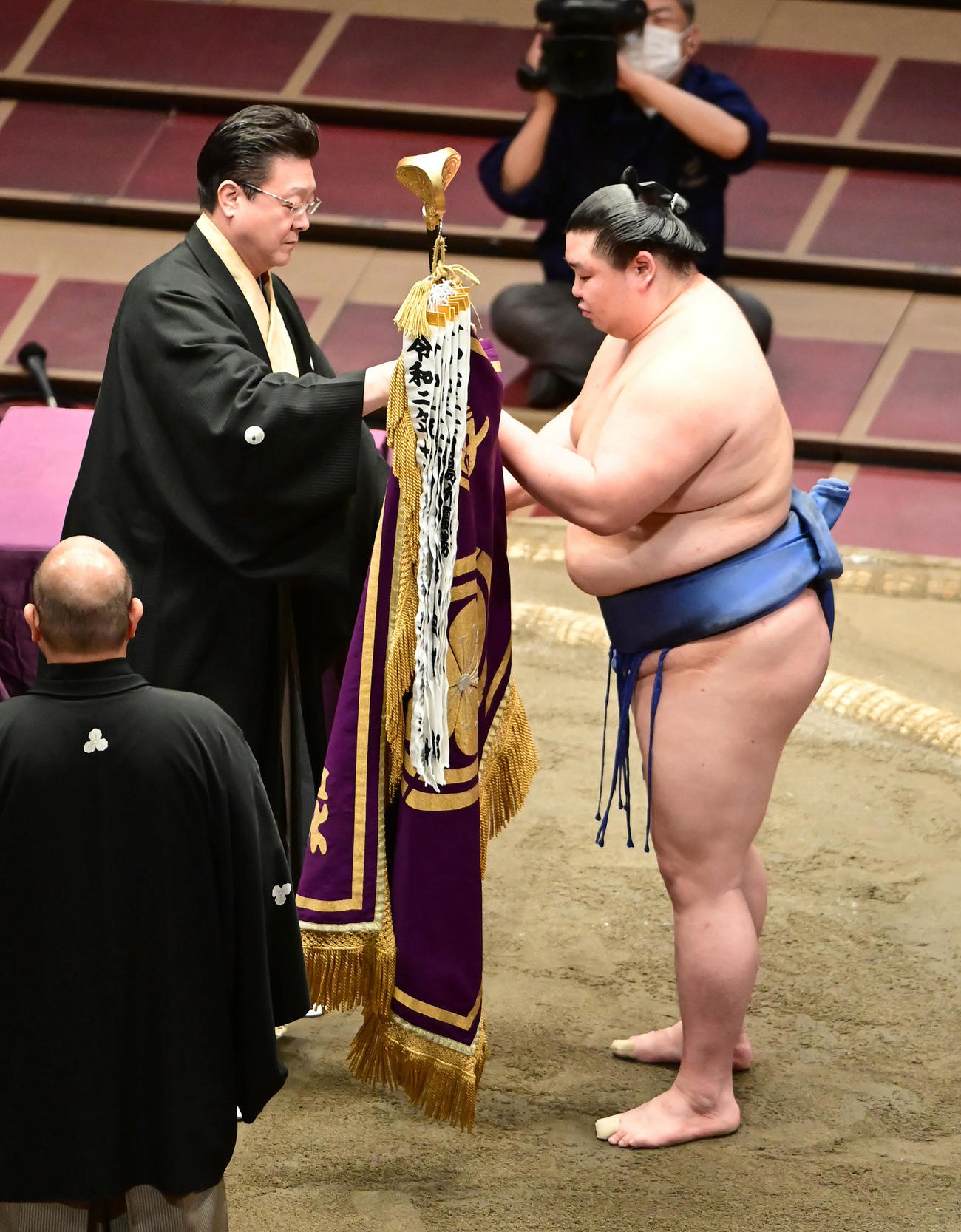 幕内初優勝を飾った正代は伊勢ケ浜審判部長（左）から優勝旗を受け取る（撮影・小沢裕）