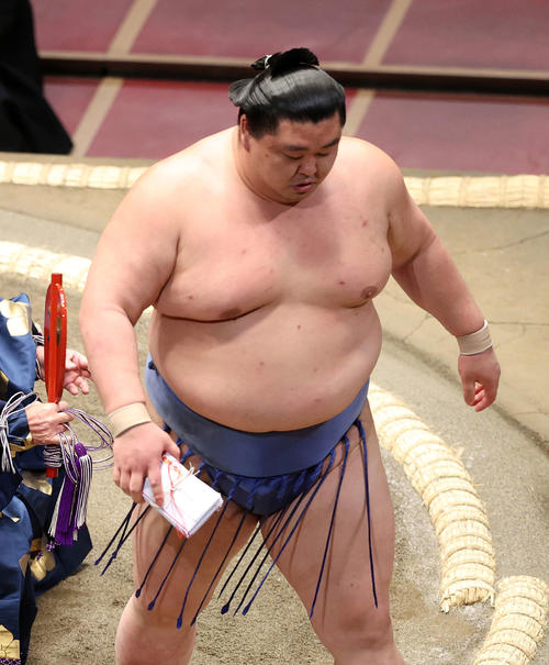 懸賞金の束を手に土俵を引き揚げる正代（撮影・鈴木正人）