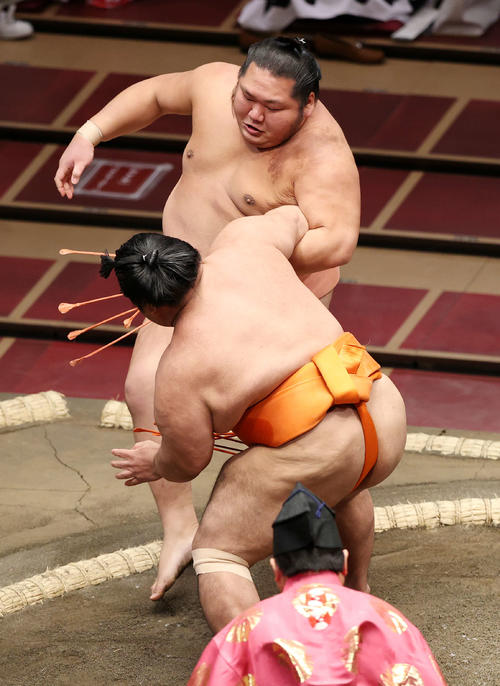 千代大龍（後方）を押し出しで破る志摩ノ海（撮影・鈴木正人）