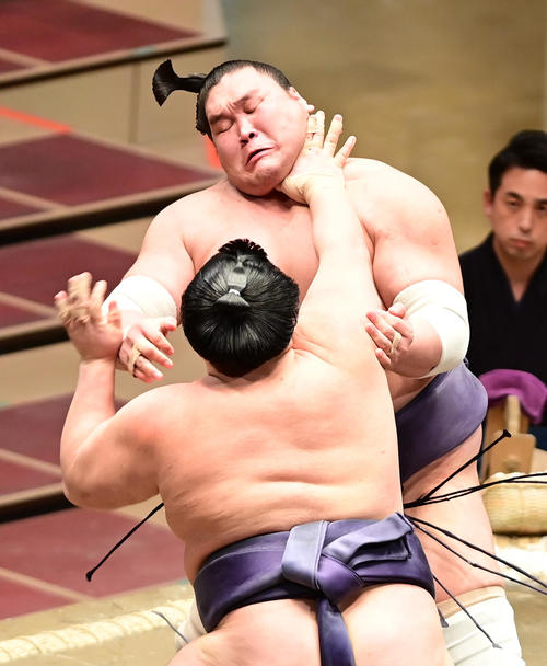 阿武咲（左）の突き押しをこらえる照ノ富士（撮影・小沢裕）