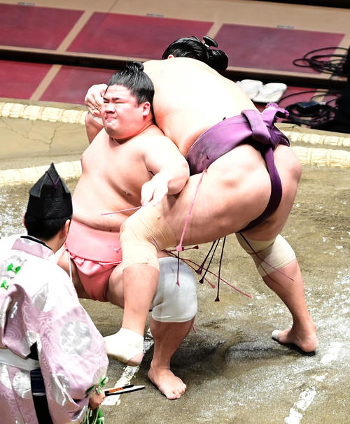 宇良（左）は居反りで旭秀鵬を破る（撮影・小沢裕）