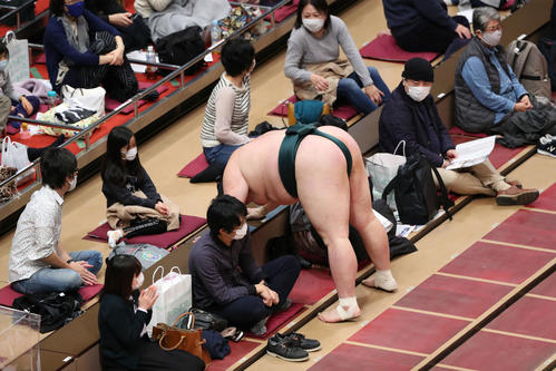 千代大龍に突き落とされ、升席手前で手をつく豊山（撮影・河田真司）