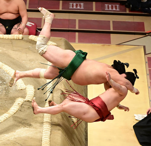 佐田の海（左）は炎鵬を寄り切りで破りそのまま土俵下に落ちる（撮影・小沢裕）