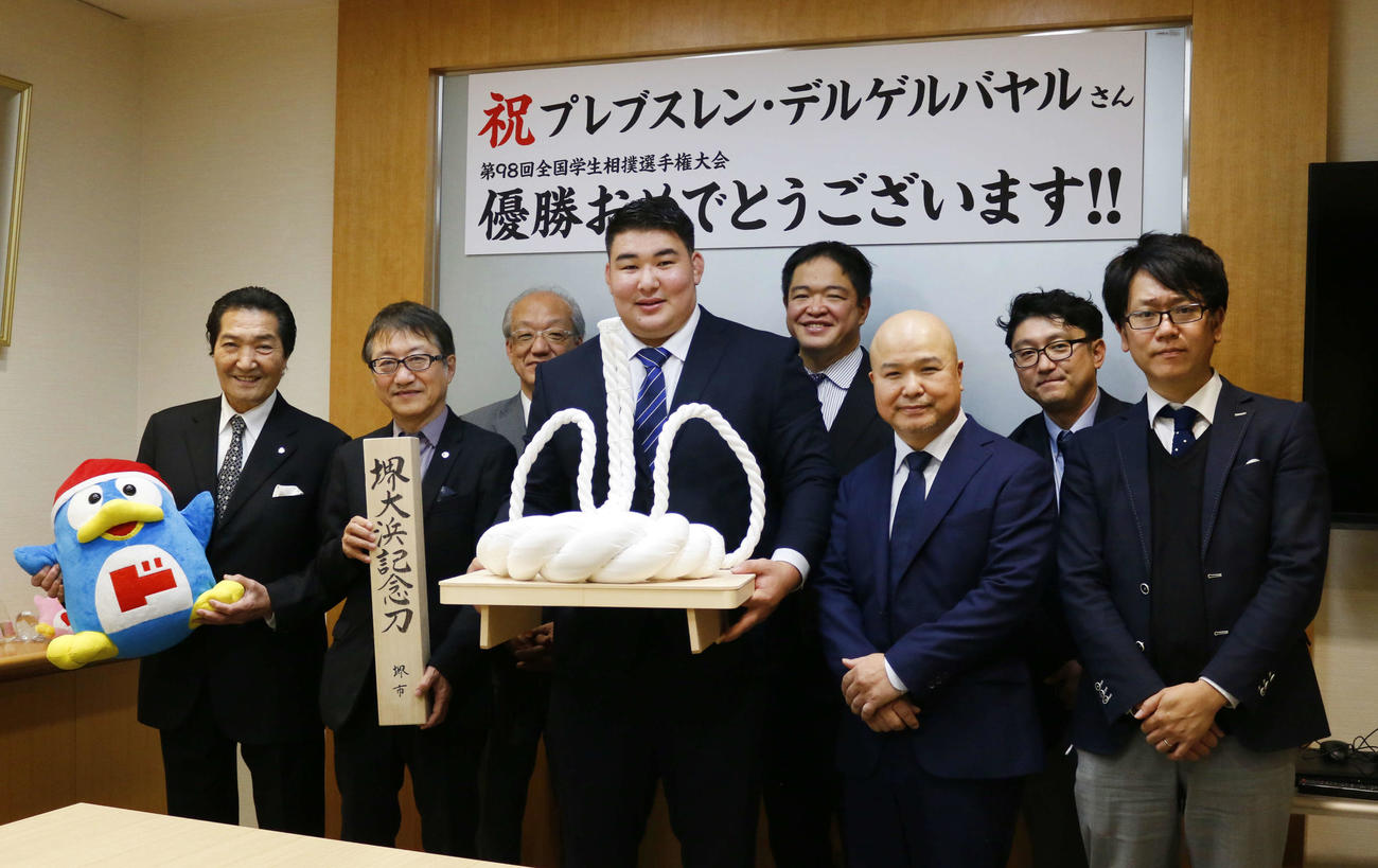 「安田奨学財団」に全国学生相撲選手権の優勝報告に訪れた日体大のデルゲルバヤル（前列左から3番目）。前列左端が日体大の松浪健四郎理事長、後列右から2番目が相撲部の斎藤一雄監督（撮影・佐藤礼征）