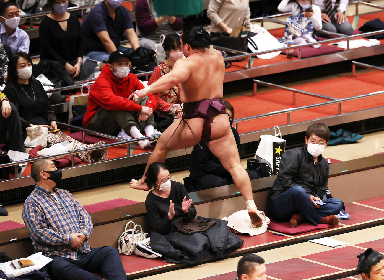 佐田の海に寄り切りで敗れマス席付近でジャンプする石浦（撮影・鈴木正人）
