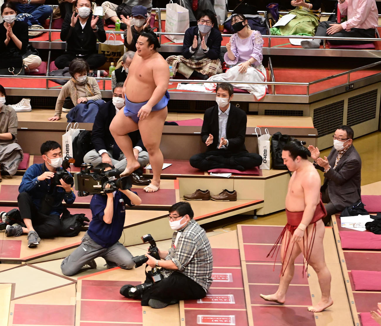 炎鵬（手前右）と翔猿（左）は勢いあまって観客席まで立ち入る熱の入った取組に館内から拍手が巻き起こった（撮影・小沢裕）