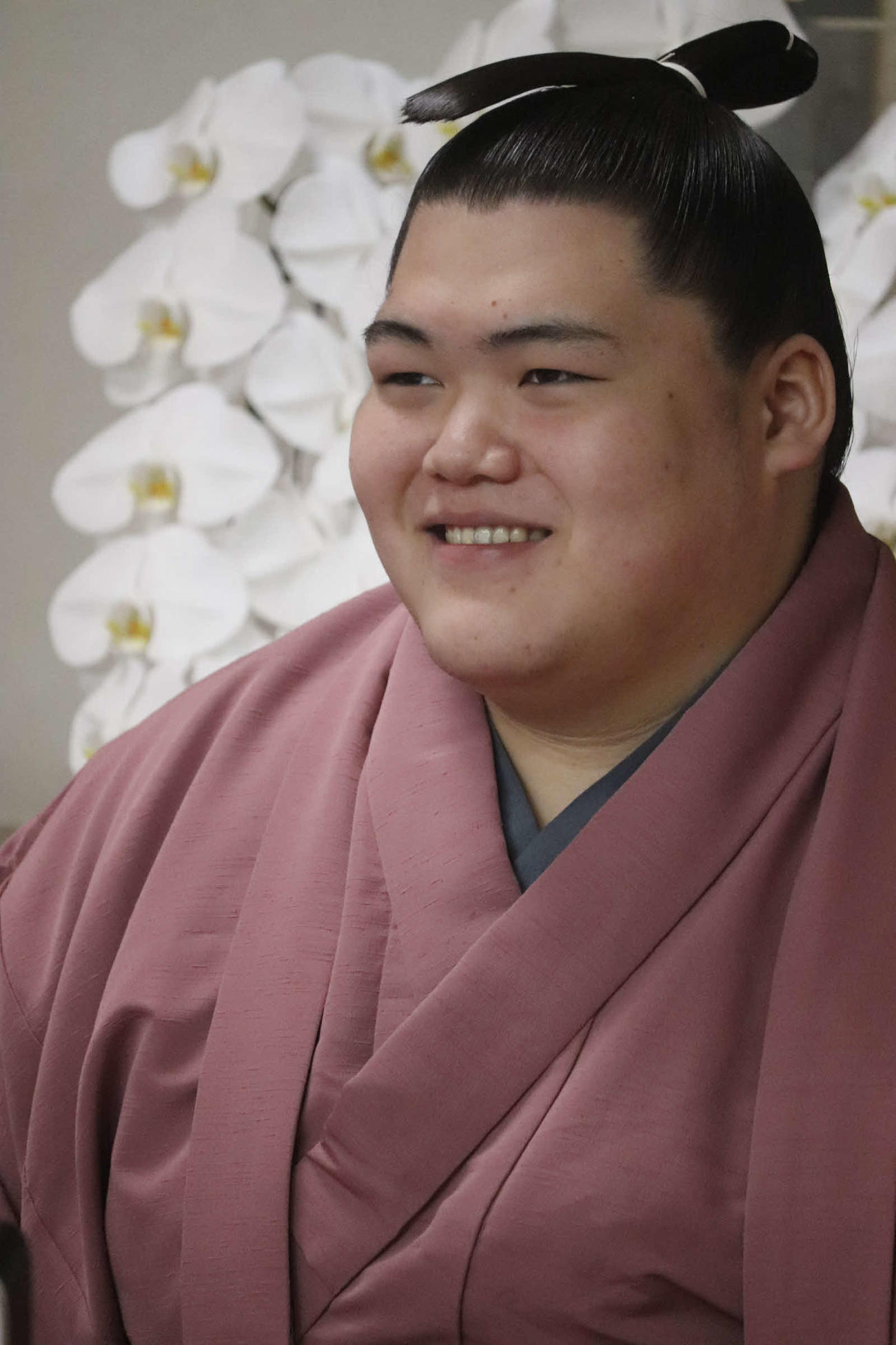 リモートでの新十両会見に臨み、笑顔を見せる納谷改め王鵬（日本相撲協会提供）