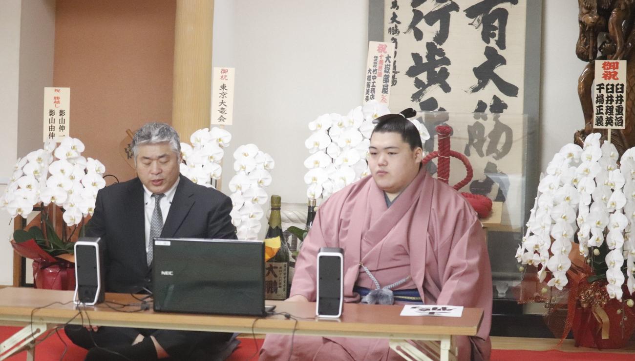 リモートでの新十両会見に臨む納谷改め王鵬（右）と師匠の大嶽親方（日本相撲協会提供）