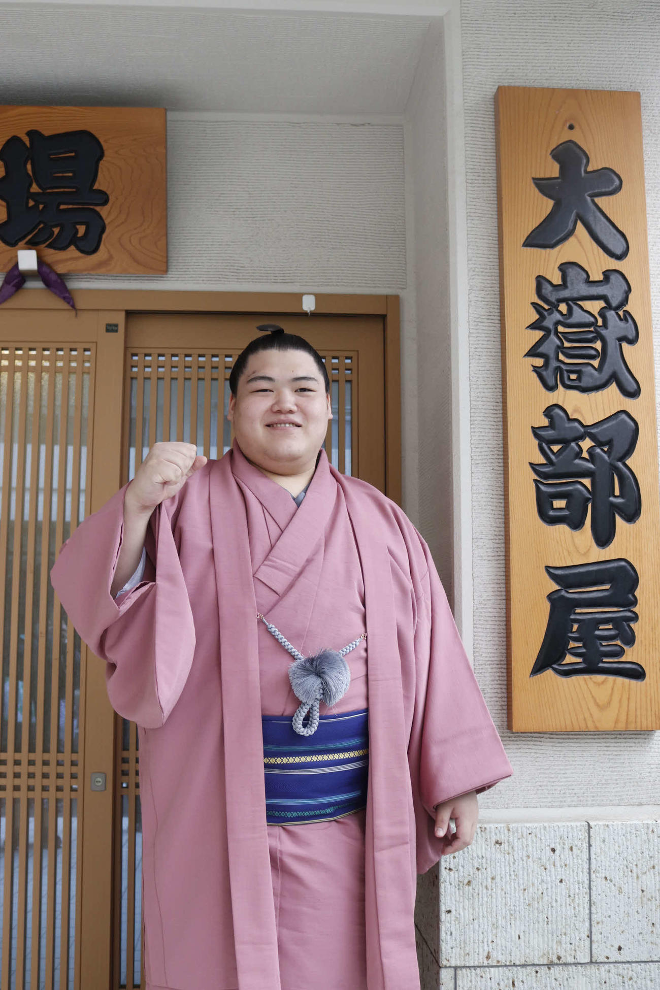 新十両昇進が決まり部屋の前でガッツポーズをする納谷改め王鵬