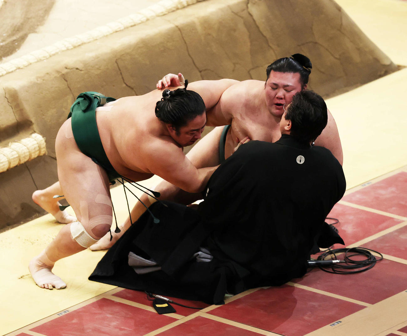 伊勢ケ浜親方（手前）に勢い余って乗りかかる佐田の海（左）と豊山（撮影・鈴木正人）