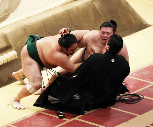 伊勢ケ浜親方（手前）に勢い余って乗りかかる佐田の海（左）と豊山（撮影・鈴木正人）