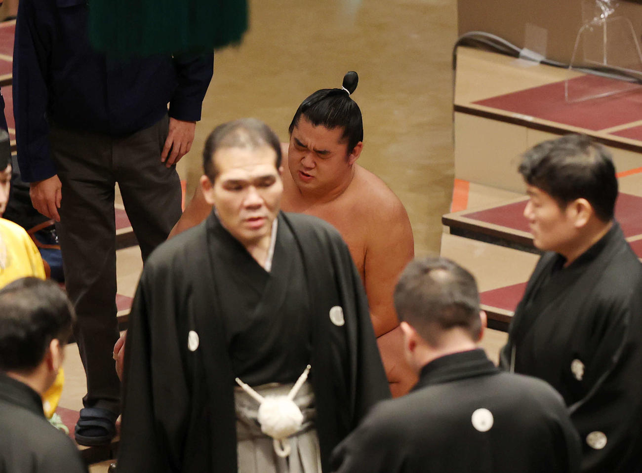 朝玉勢との立ち合いが不成立となるもフラフラになり立てない湘南乃海（後方）は審判団が話し合う中、花道で険しい表情を見せる（撮影・河野匠）