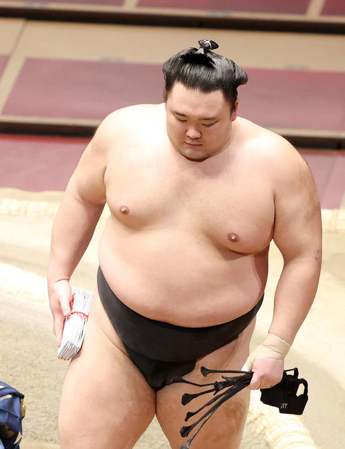 懸賞金の束を手に土俵を引き揚げる朝乃山（撮影・鈴木正人）